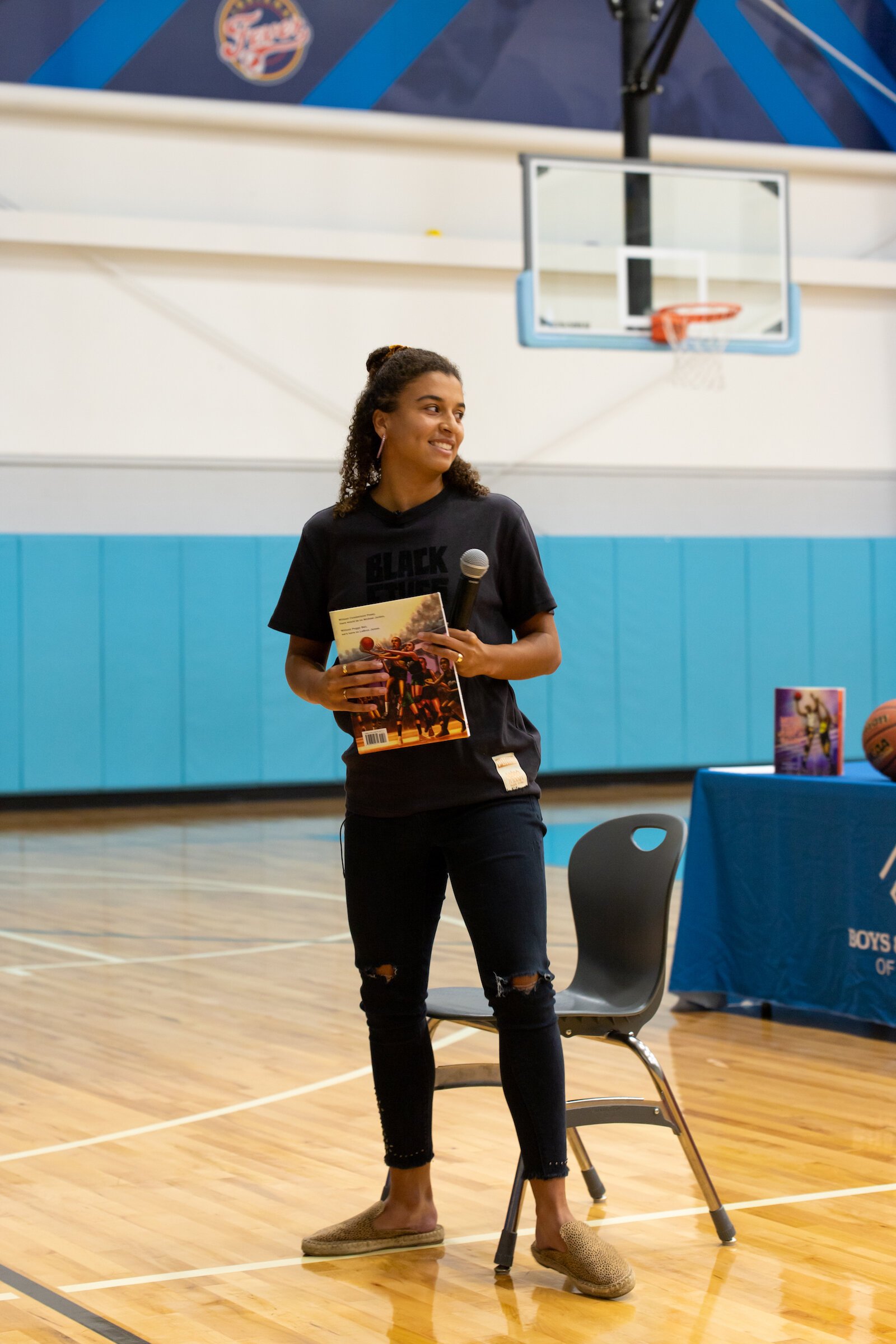 Madison Moore, a Fort Wayne-raised author of "More Than Just a Game: The Black Origins of Basketball," signs copies of her book at the Fort Wayne Boys & Girls Club.