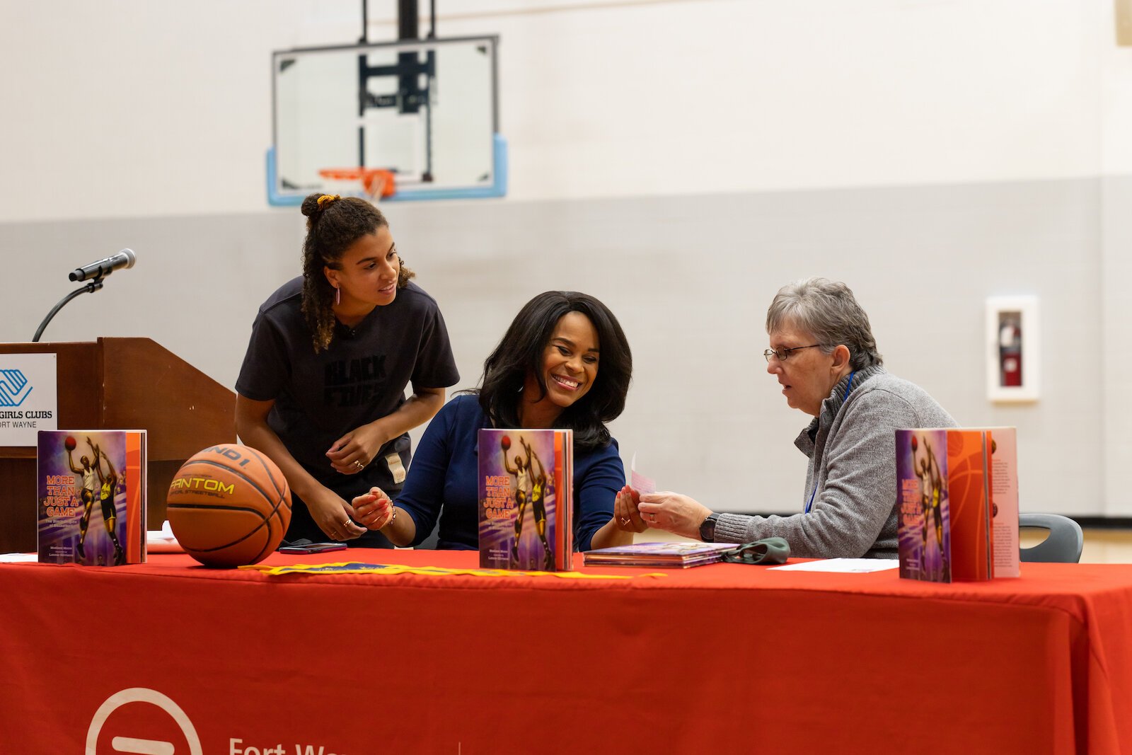 Madison Moore, a Fort Wayne-raised author of "More Than Just a Game: The Black Origins of Basketball," signs copies of her book at the Fort Wayne Boys & Girls Club.