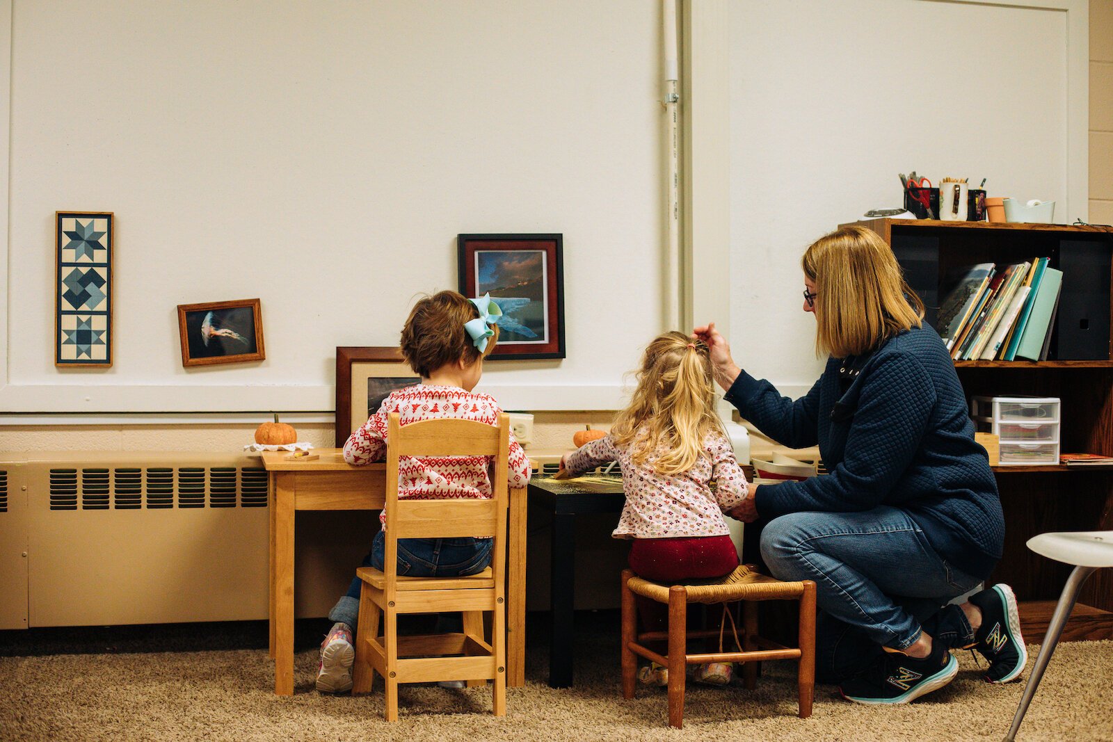 A guide (teacher), works with children on classroom activities.