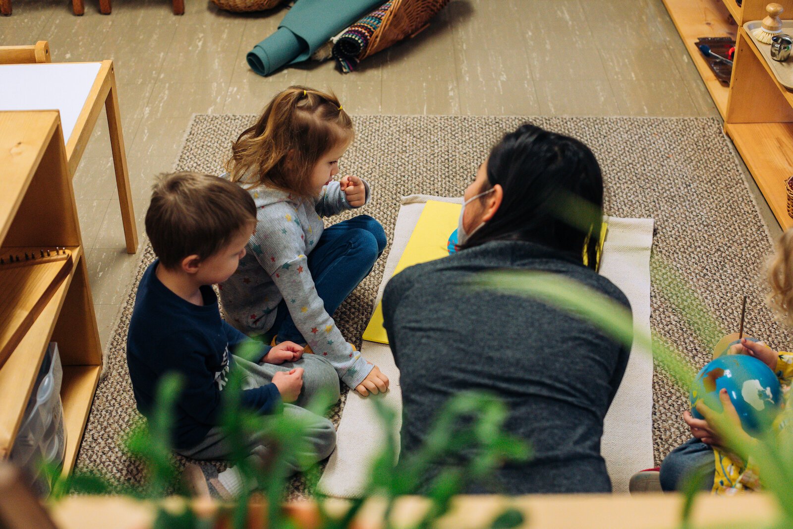 A guide (teacher), works with children on classroom activities.