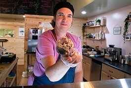 Julie Hurd, owner of Moo-Over Ice Cream, scoops her vegan, plant-based "Cookies in Pink" ice cream at her shop in Columbia City.