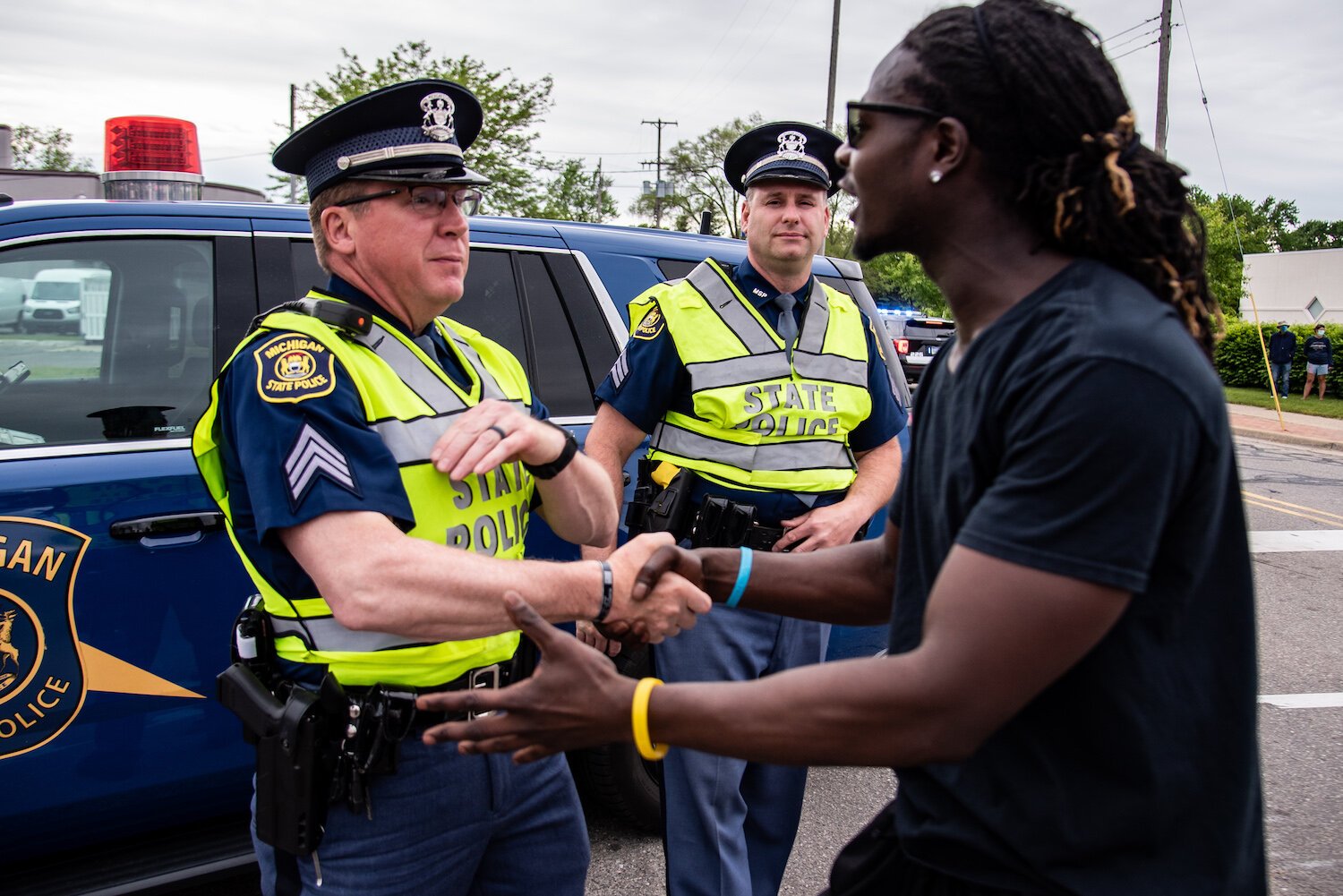 Trokon Jayqua, right, thanks police officers during a march to protest the death of George Floyd and social injustice June 1 on Mission Street in Mount Pleasant, MI.