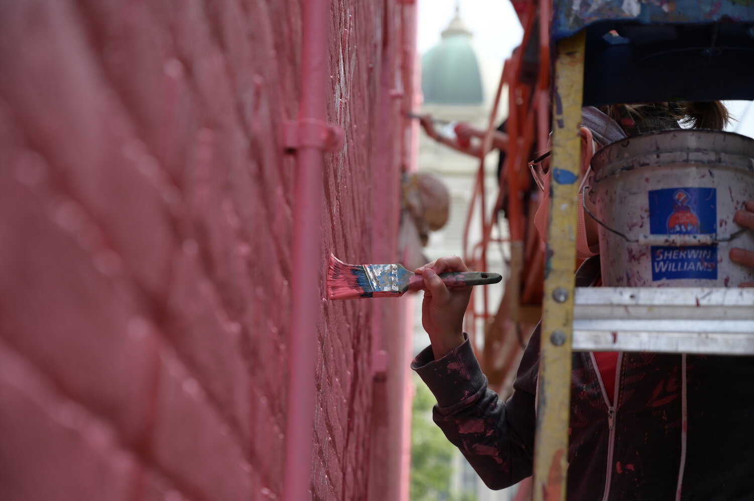 Artists assist Shawn Dunwoody with a mural in downtown Columbia City.