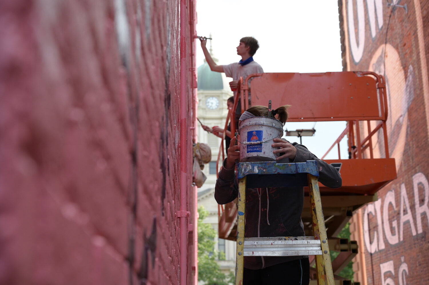 Artists assist Shawn Dunwoody with a mural in downtown Columbia City.