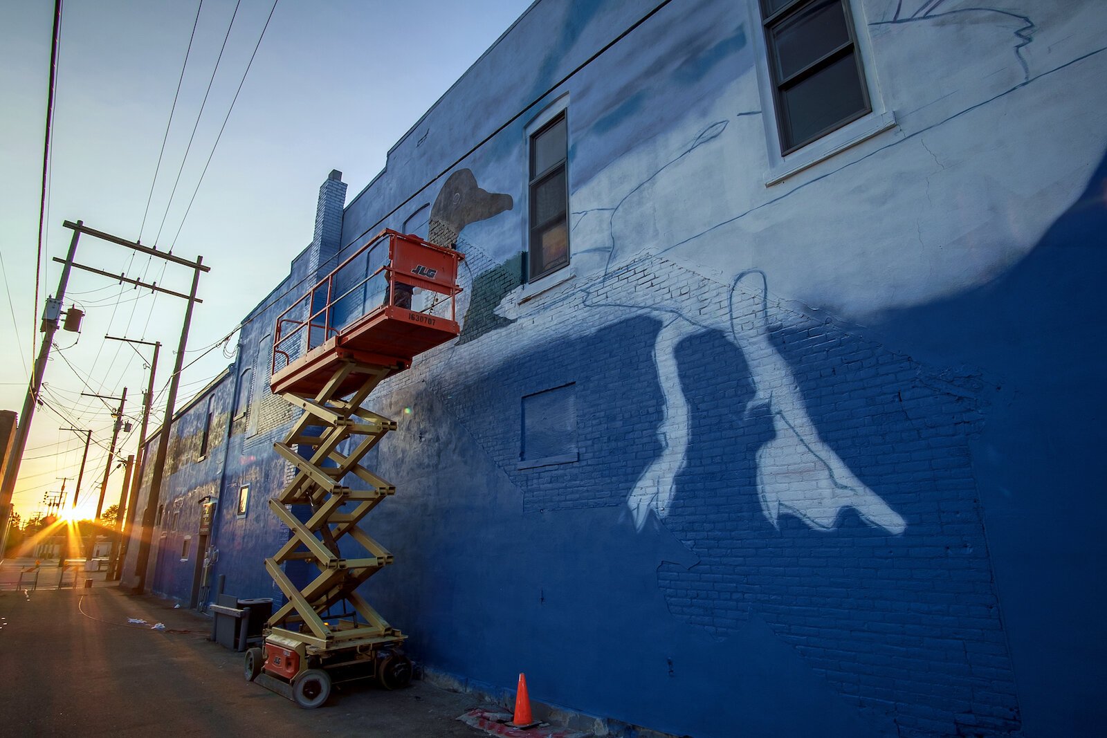 Tim Parsley works on a mural in downtown Warsaw.