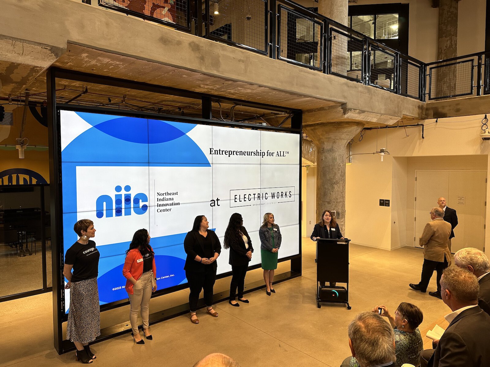 Tammy Allen from NIIC introduces the NIIC business coaches at a press conference at Electric Works. 