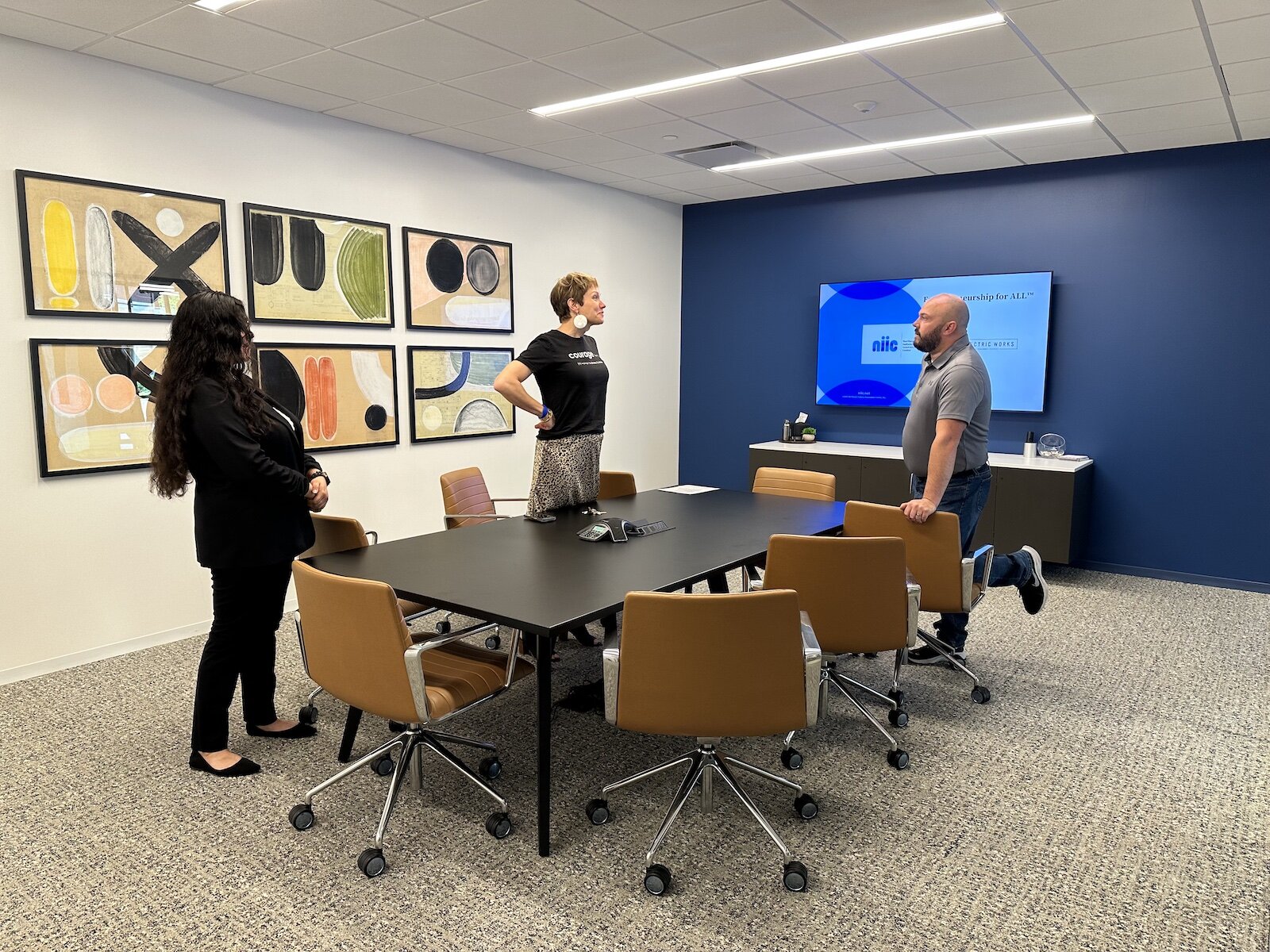 Samantha Cazares (left) and Leslee Hill (middle), NIIC Business Coaches talk with a visitor at Carr Workplaces at Electric Works.