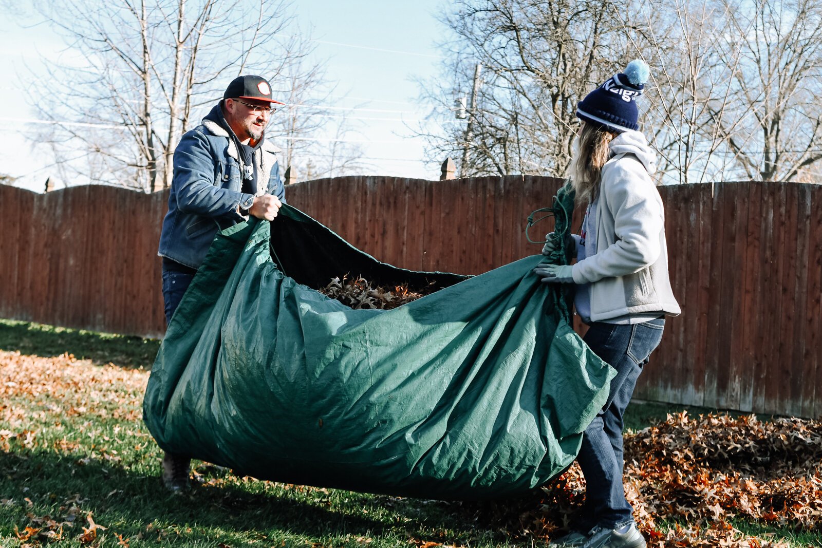 Eric Wood, Executive Director and Megan Chandler, Development Coordinator of NeighborLink work together to clear leaves while volunteering at a home in Fort Wayne.