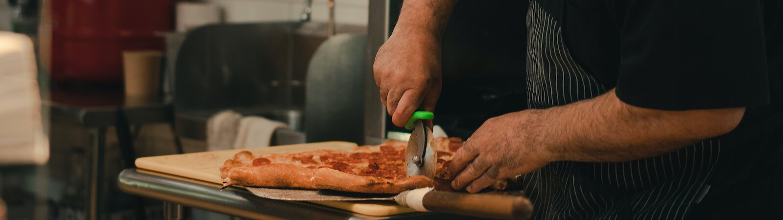 Johnny Bojinoff, owner of Johnny OX Pizzeria, cuts a freshly-made pie.