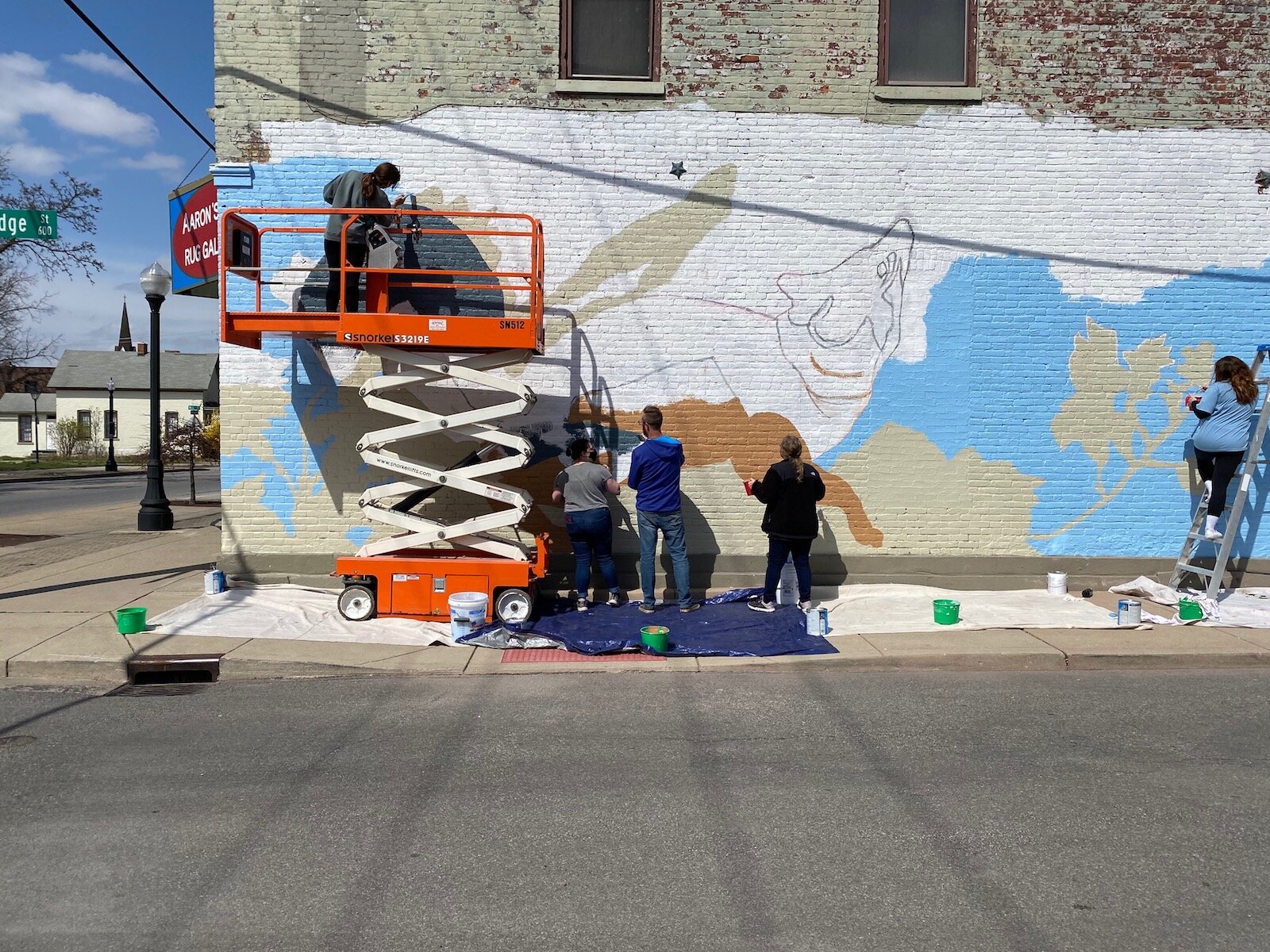 USF’s Mural Painting and Public Art Class works on a mural in downtown Fort Wayne at 1217 Broadway.