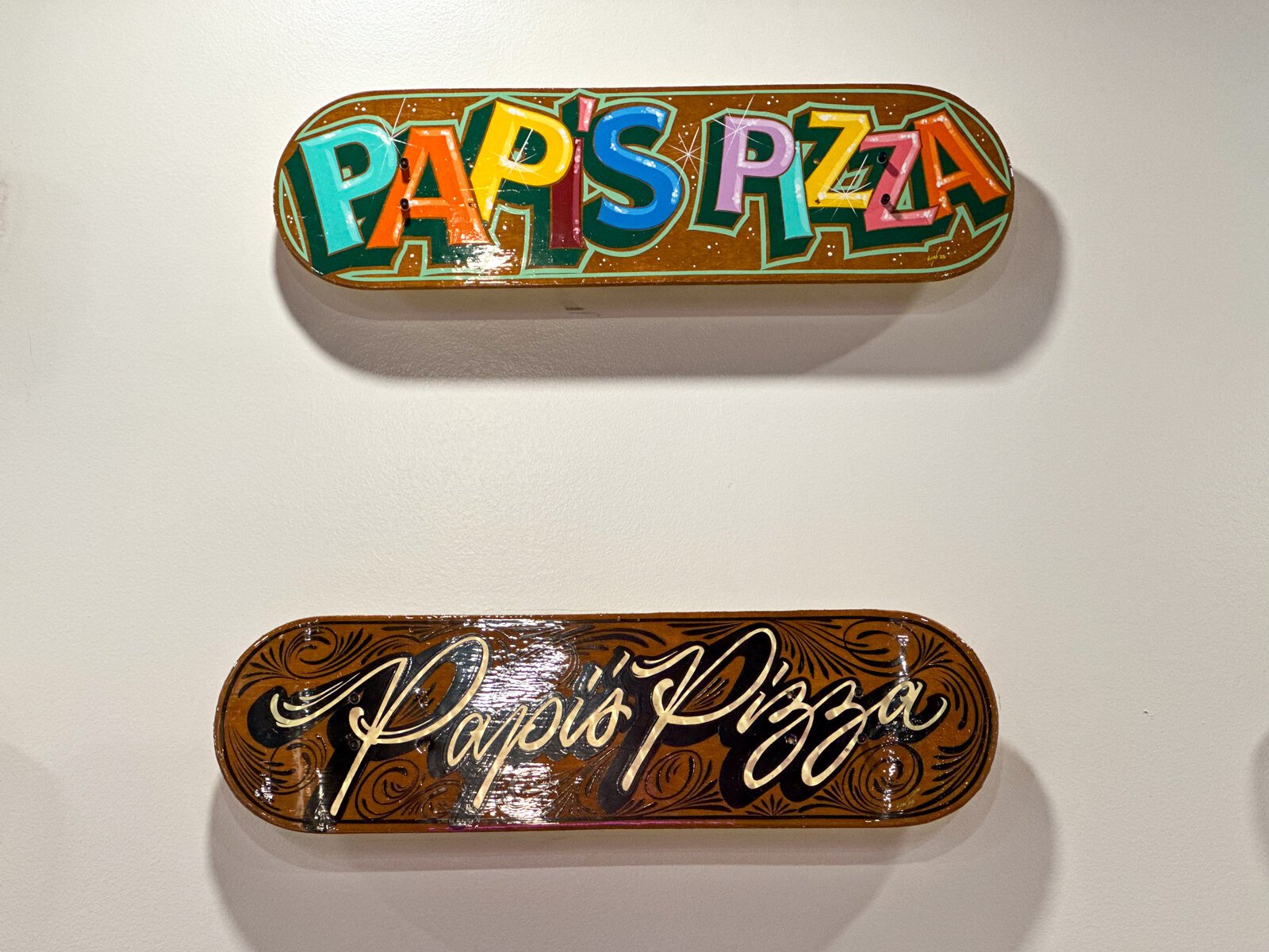 Skate decks painted by local artists inside Papi's Pizza Company on The Landing in Downtown Fort Wayne.