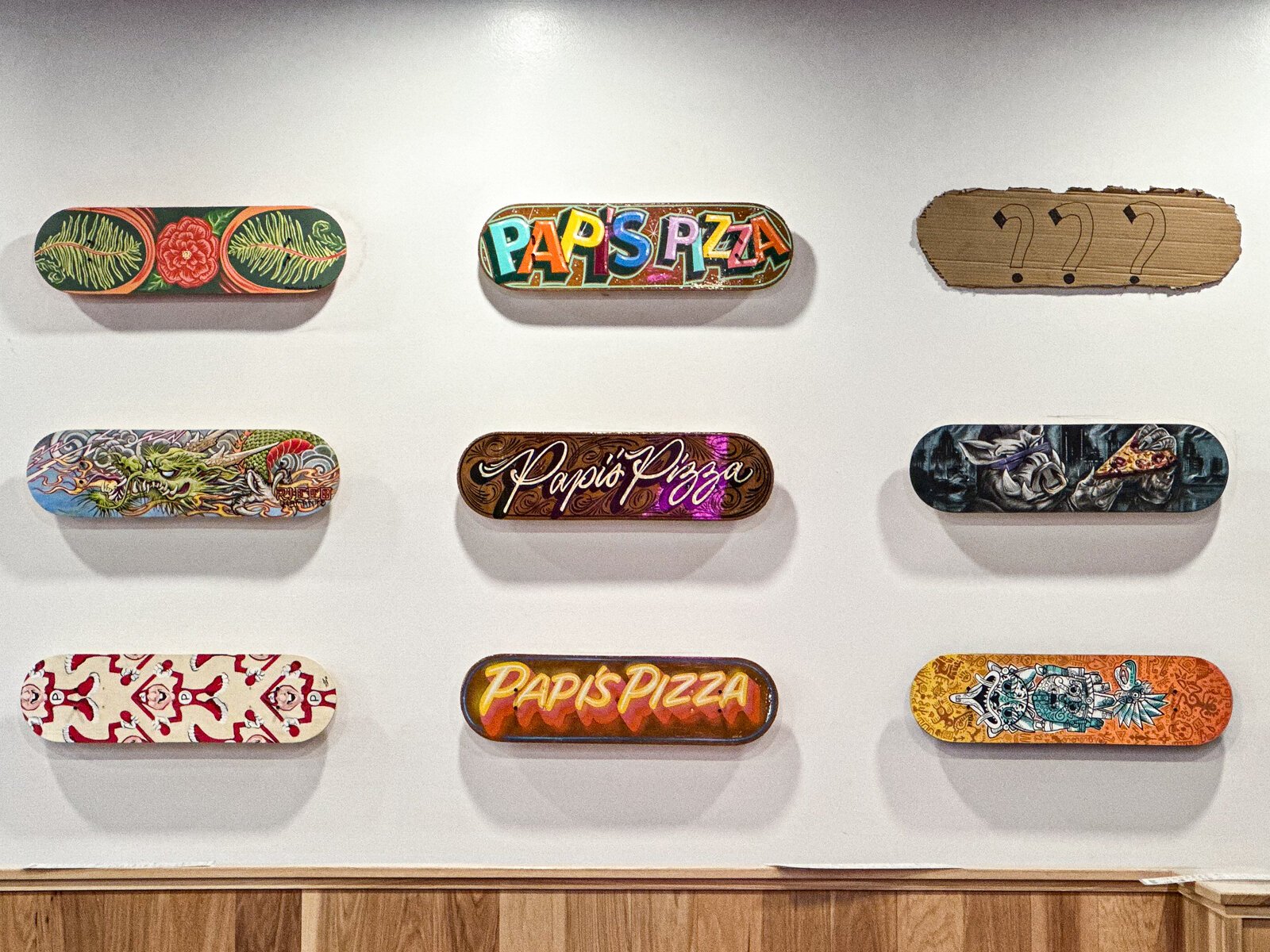 Skate decks painted by local artists inside Papi's Pizza Company on The Landing in Downtown Fort Wayne.