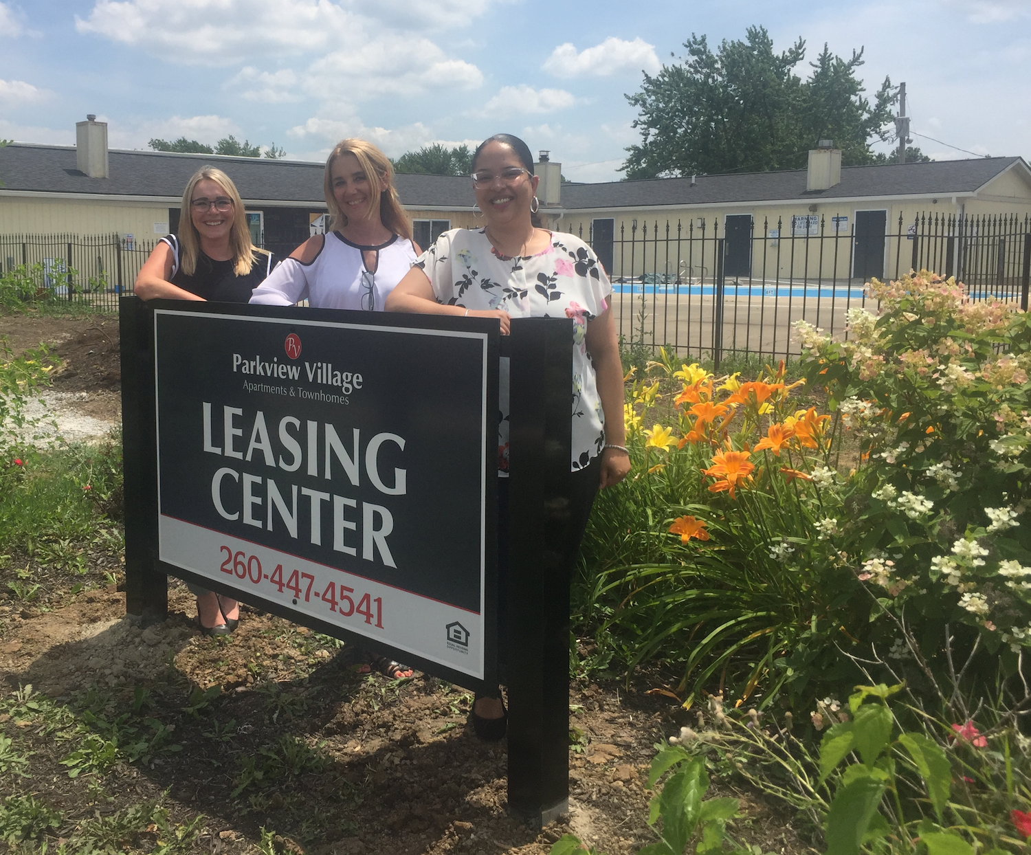 Tiffany Brewer, Karen Birsfield, and Melonie Bradtmueller stand in front of what will be the future leasing center at Parkview Village.