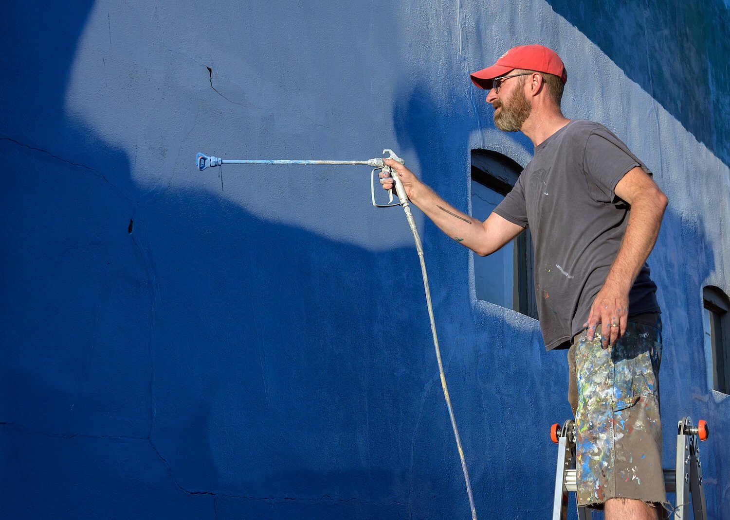 Tim Parsley works on a mural in downtown Warsaw.