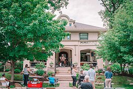 People gather to watch live music on a Williams Woodland Park front porch.