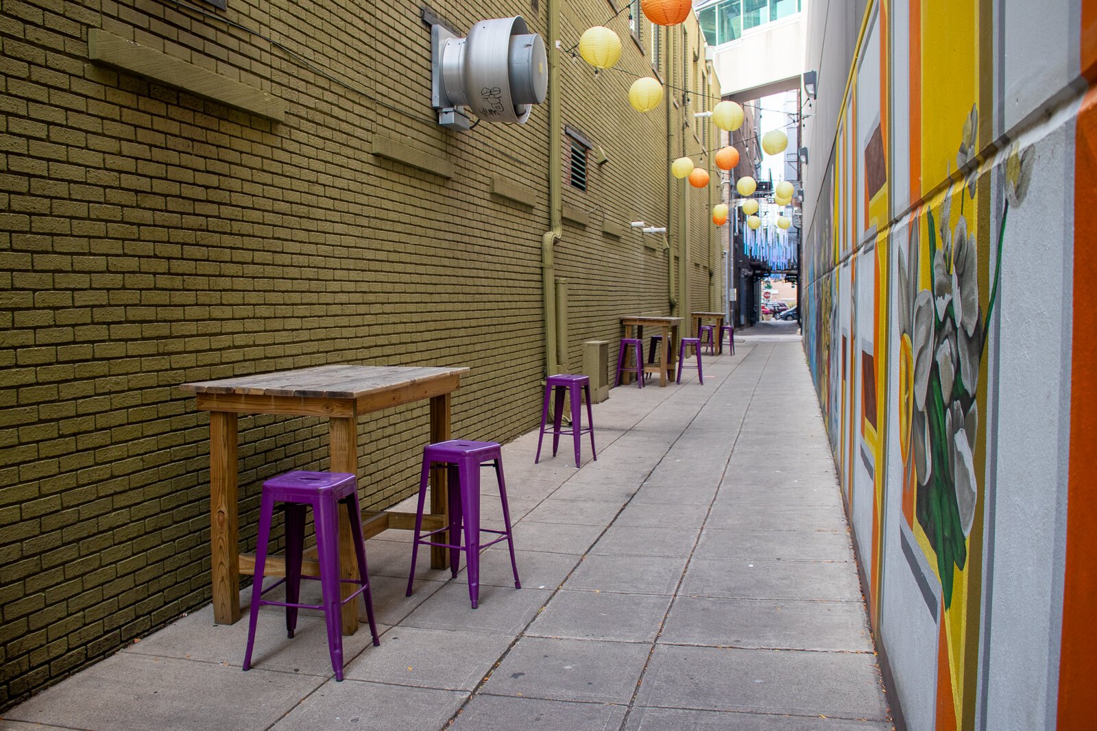 Seats and tables line the alleys near the TriCore Porch Off Calhoun.