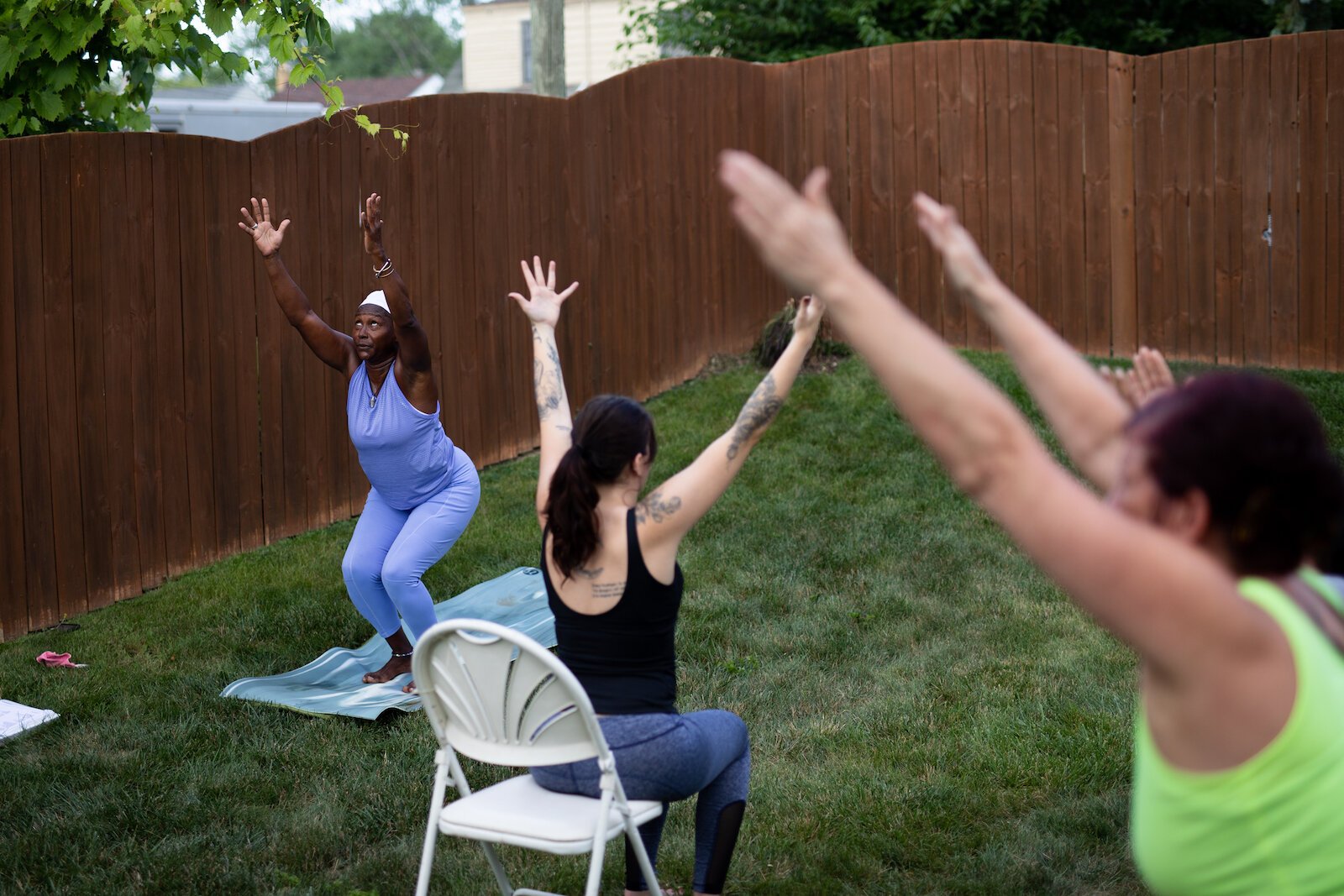 Diane Rogers, left, a longtime resident and current President of the Oxford Community Association, leads a yoga class in her backyard for her neighborhood and community drop-ins.