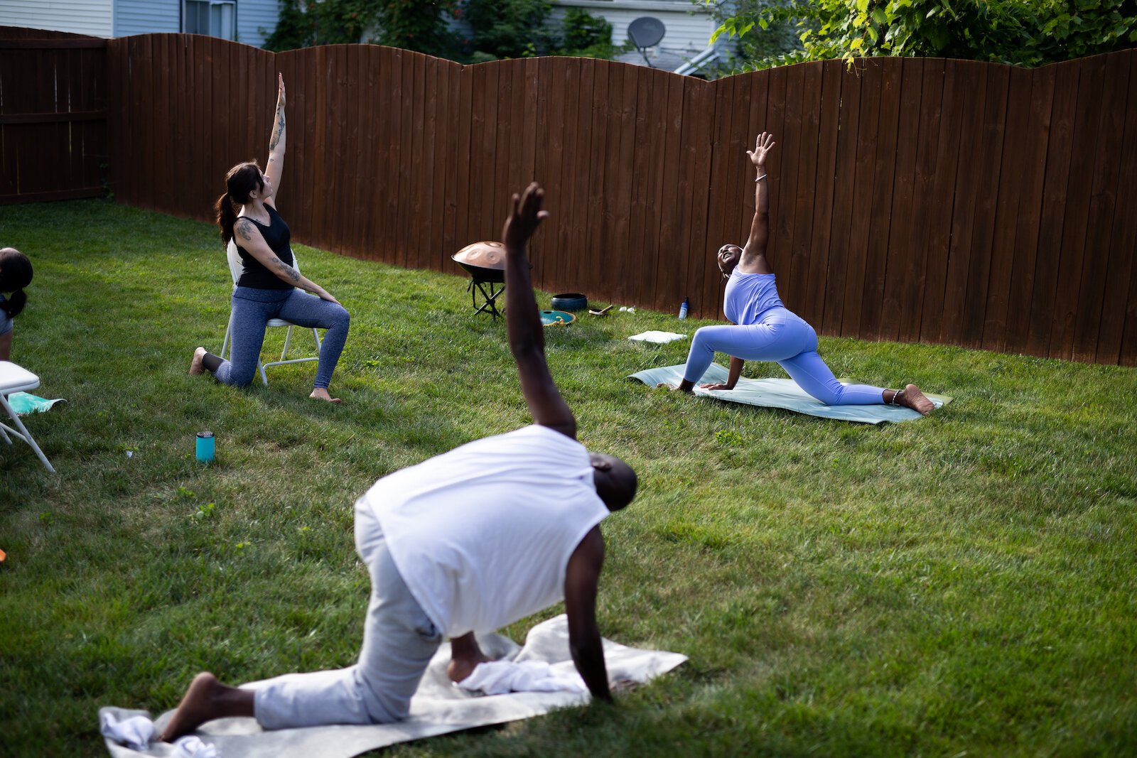 Diane Rogers, back right, a longtime resident and current President of the Oxford Community Association, leads a yoga class in her backyard for her neighborhood and community drop-ins.