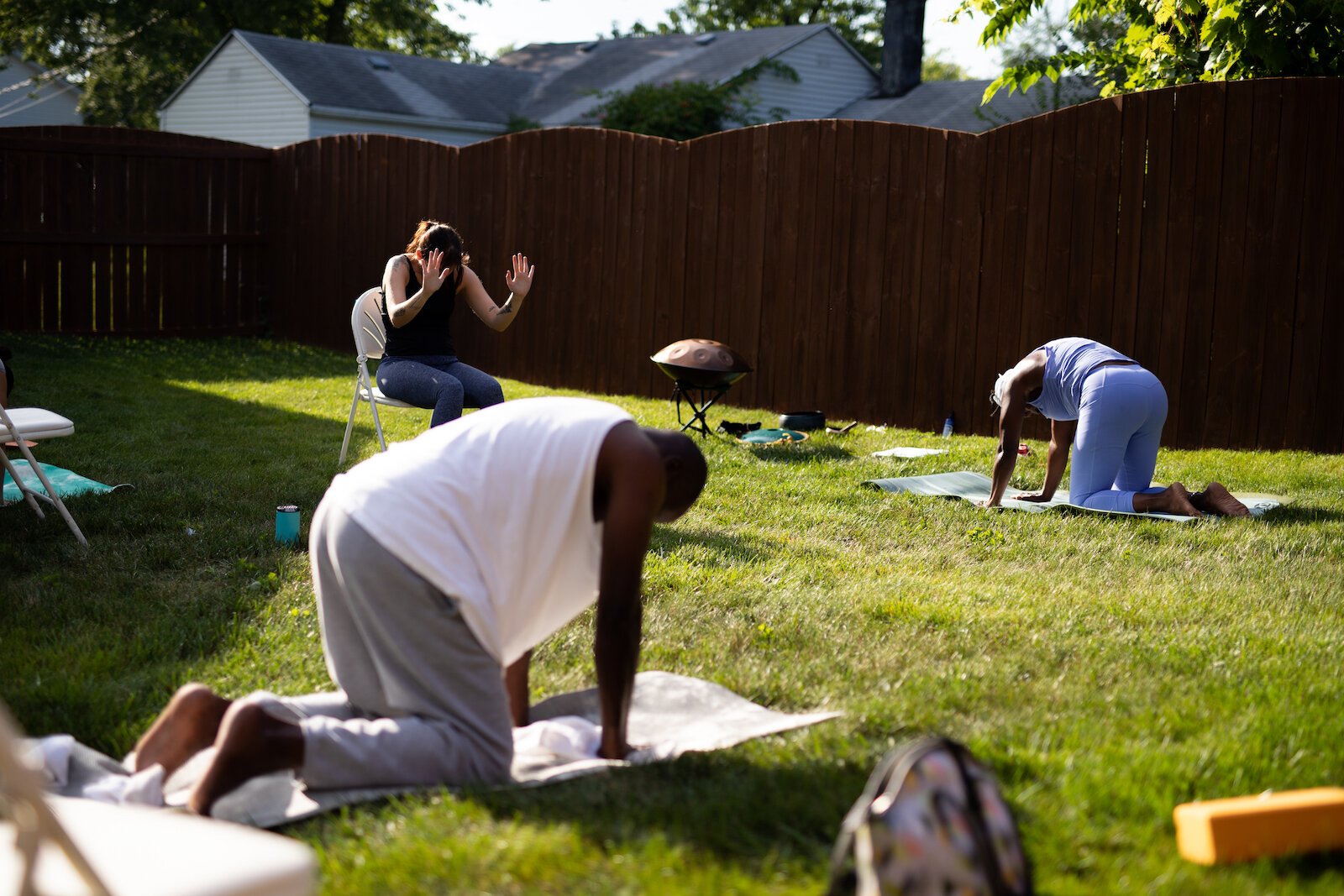 Diane Rogers, back right, a longtime resident and current President of the Oxford Community Association, leads a yoga class in her backyard for her neighborhood and community drop-ins.