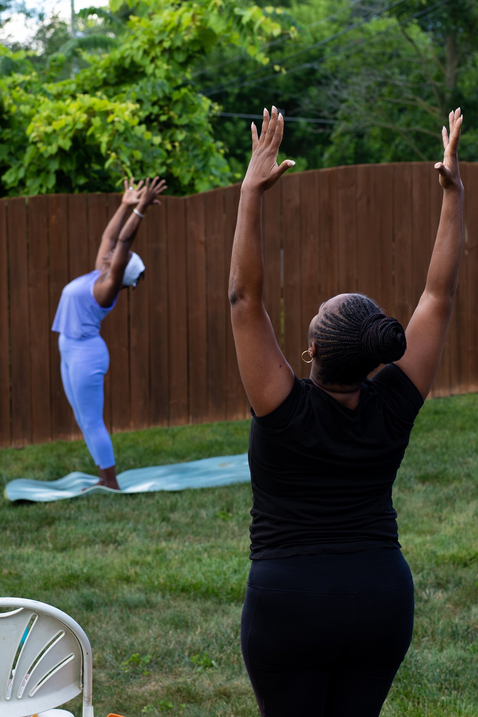 Diane Rogers, left, a longtime resident and current President of the Oxford Community Association, leads a yoga class in her backyard for her neighborhood and community drop-ins.