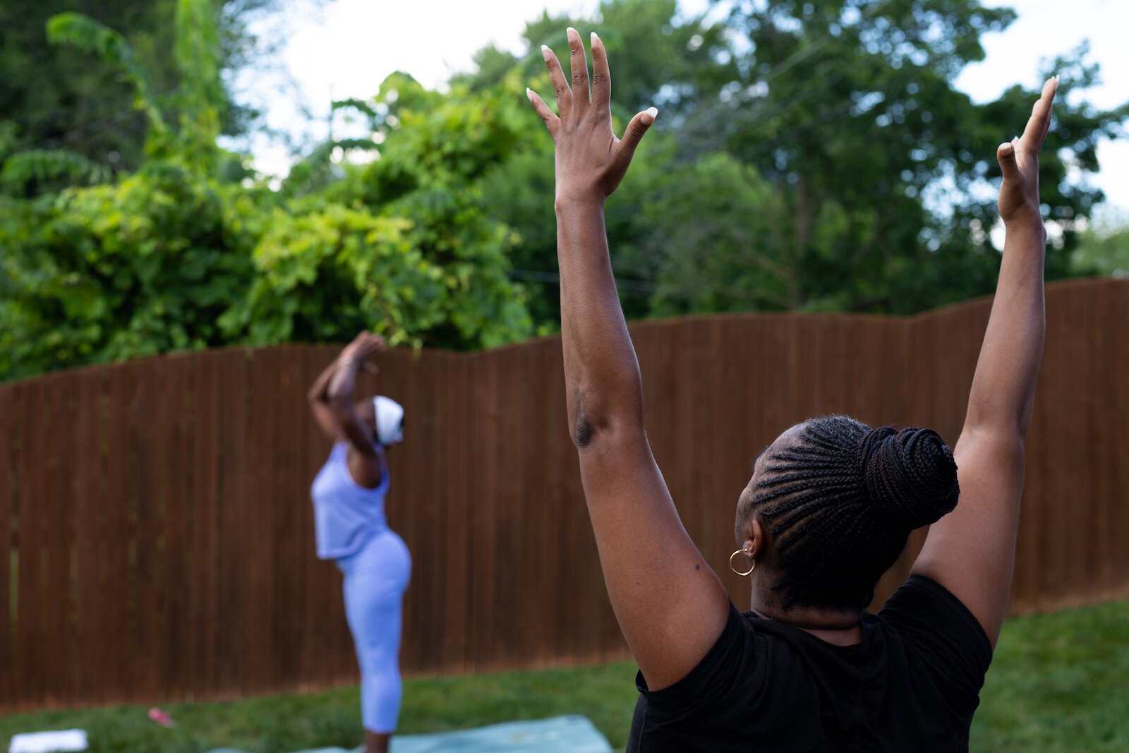 Diane Rogers, left, a longtime resident and current President of the Oxford Community Association, leads a yoga class in her backyard for her neighborhood and community drop-ins.