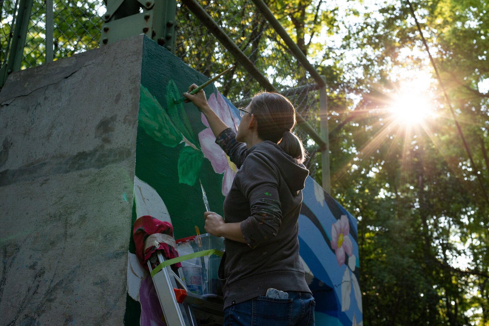 Suzanne Rhee works on her mural in Foster Park.