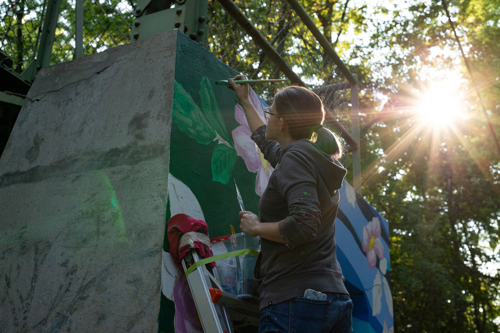 Suzanne Rhee works on her mural in Foster Park.