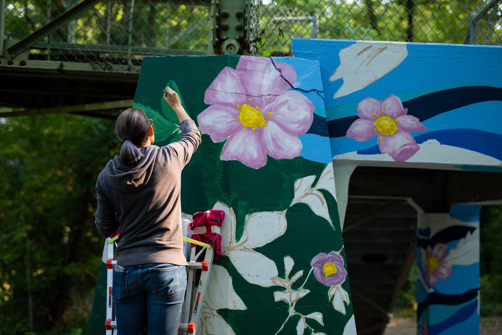 Suzanne Rhee works on her mural in Foster Park.