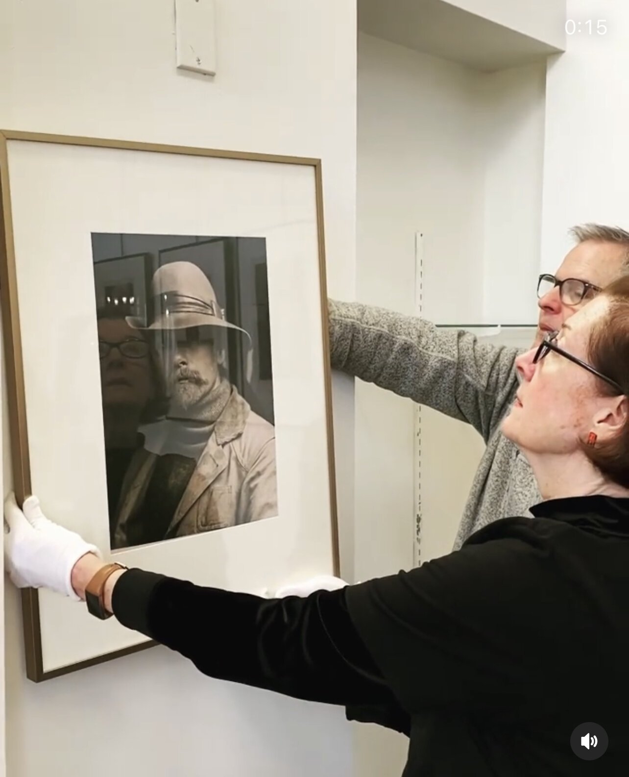 Gallery Coordinator and Curator Angela Green and Museum Director Jim Gabbard install a piece by Edward Curtis.