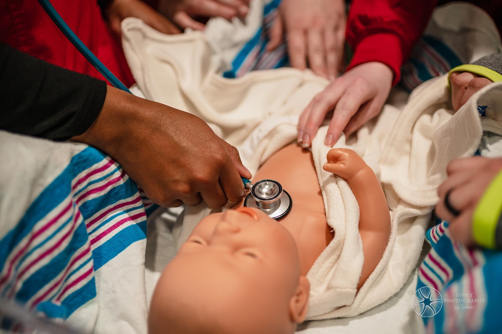 With the help of Parkview Nurse and Indiana University Fort Wayne Instructor Roni Elliott, an IUFW student simulates taking vitals on an infant.