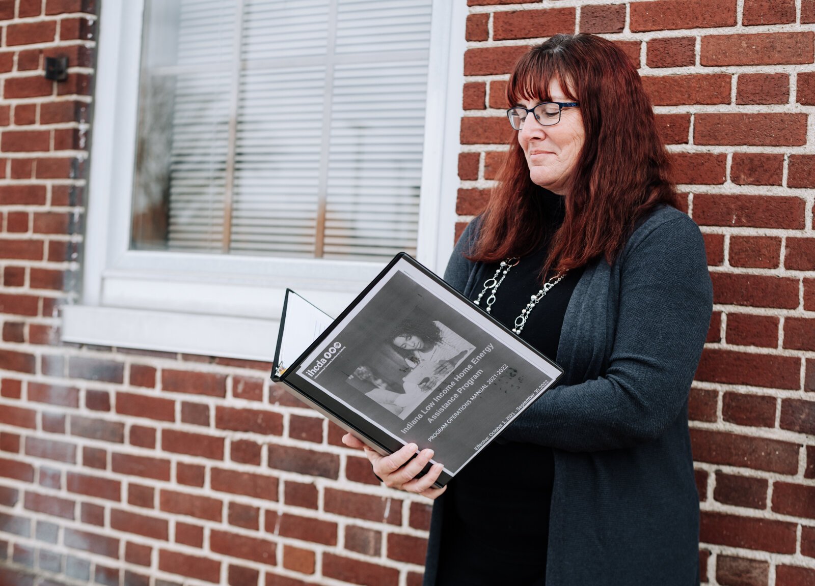 Lesa Cassel, Brightpoint Family Support Services Manager, holds up information about the Indiana Low Income Home Energy Assistance Program.