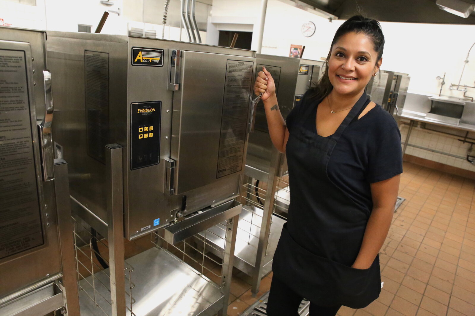 Ruiz poses with her favorite kitchen tool: The industrial steamers at the Community Harvest Food Bank's shared kitchen.