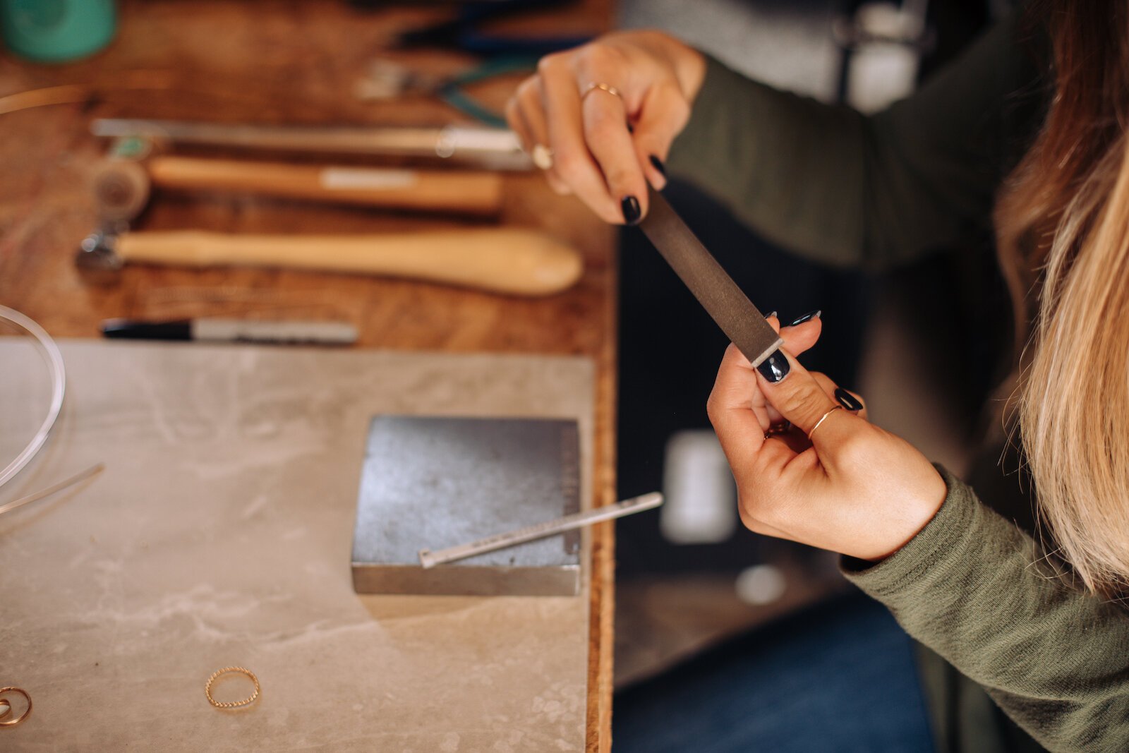 Still Remains Owner Raelyn Bever works on a ring in her garage workspace.