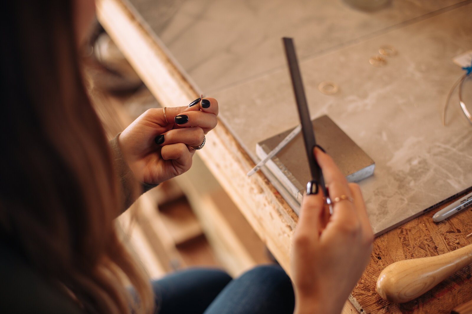 Still Remains Owner Raelyn Bever works on a ring in her garage workspace.