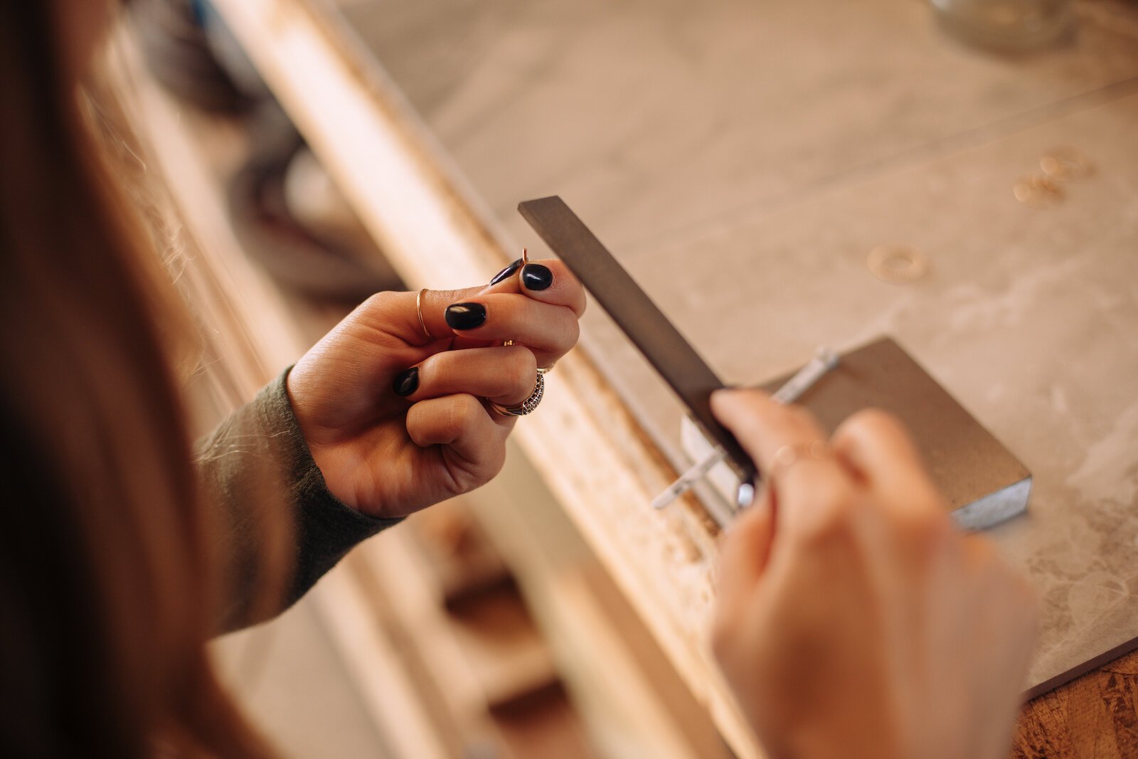 Still Remains Owner Raelyn Bever works on a ring in her garage workspace.