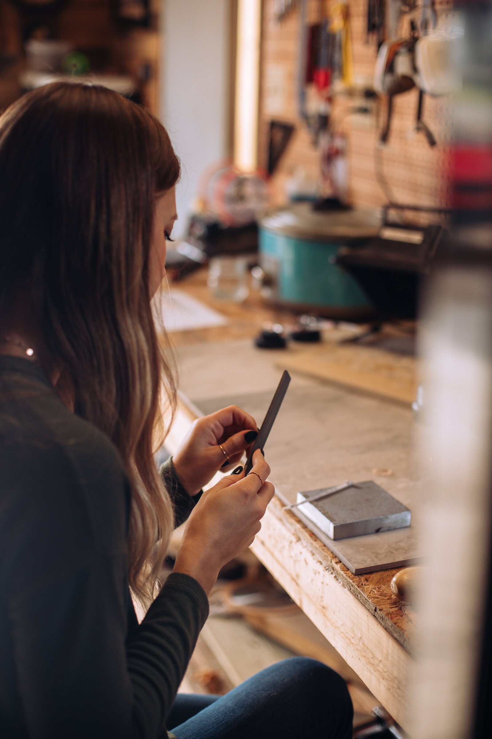 Still Remains Owner Raelyn Bever works on a ring in her garage workspace.