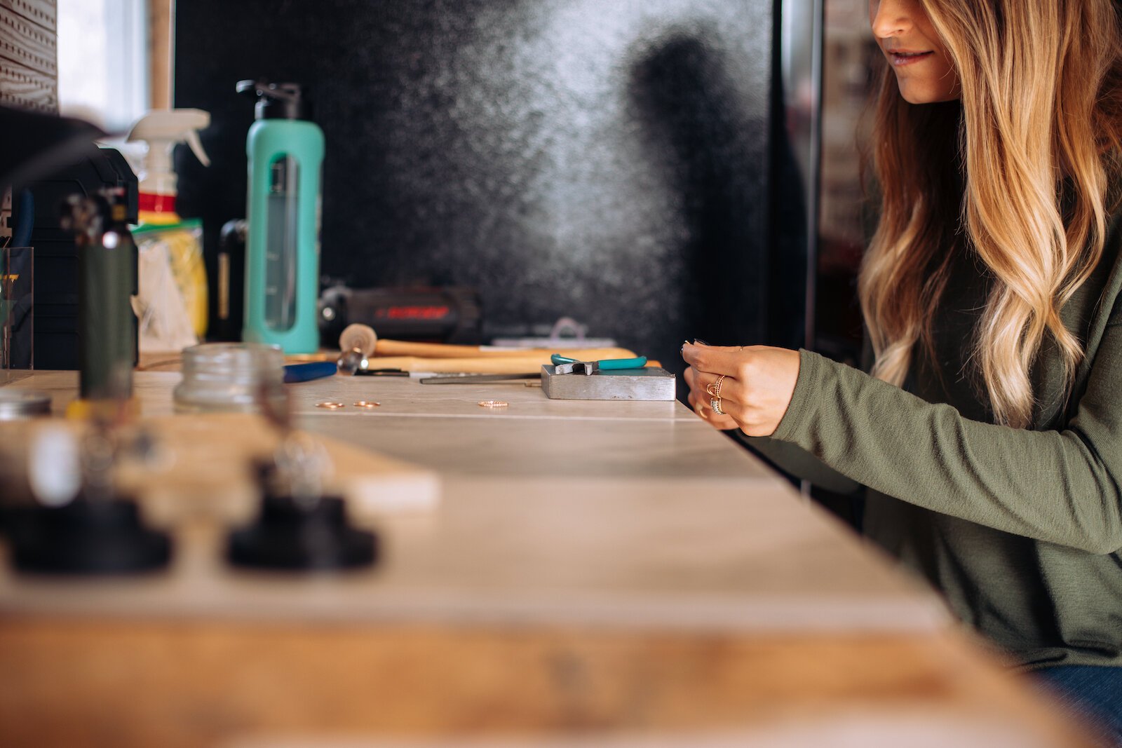 Still Remains Owner Raelyn Bever works on a ring in her garage workspace.