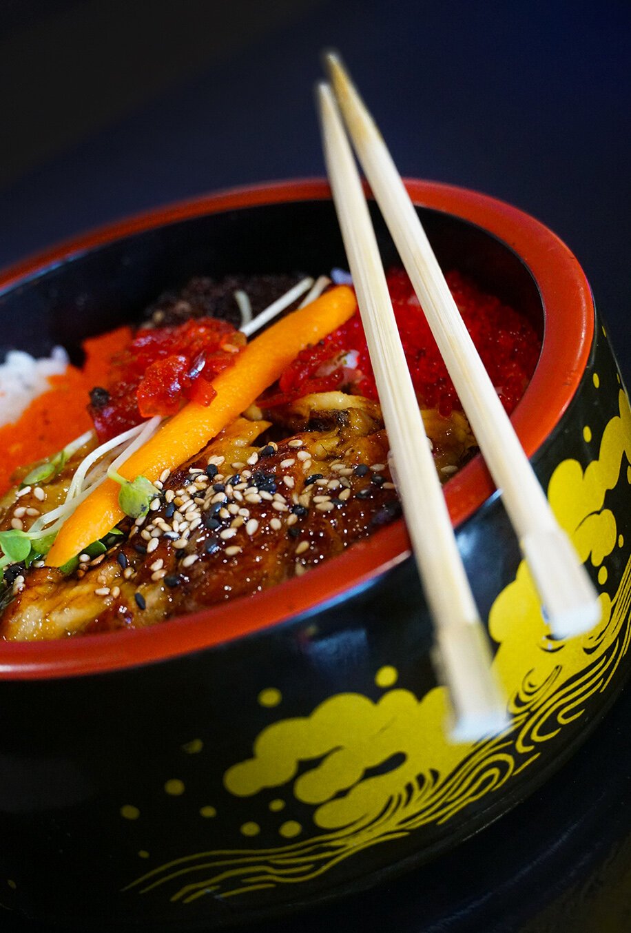 The unagi donburi is presented beautifully with colorful sections of eel, tobiko, and masago placed over subtly seasoned rice.