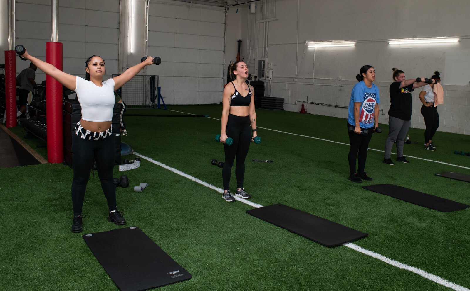 Participants in a group workout hosted by Tori Leigh Fitness at Traction Athletic Performance gym.