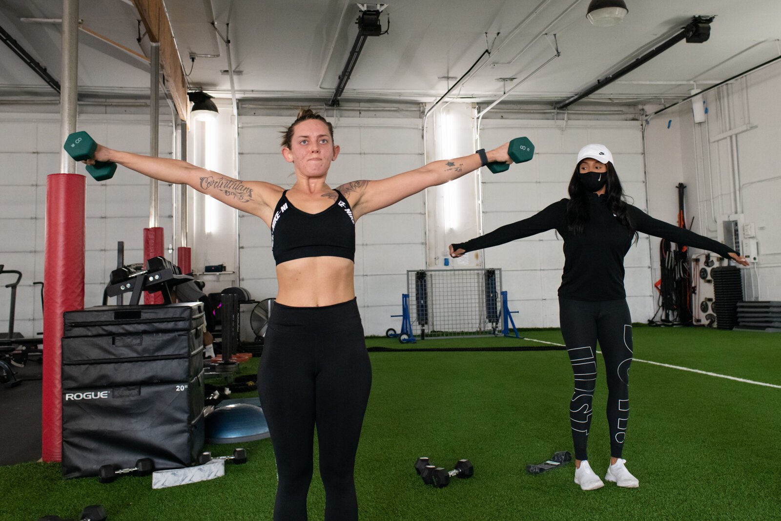 Victoria "Tori" Soto of Tori Leigh Fitness, right, exercises with participant Kaytlin Callaway, left, during a small group workout.