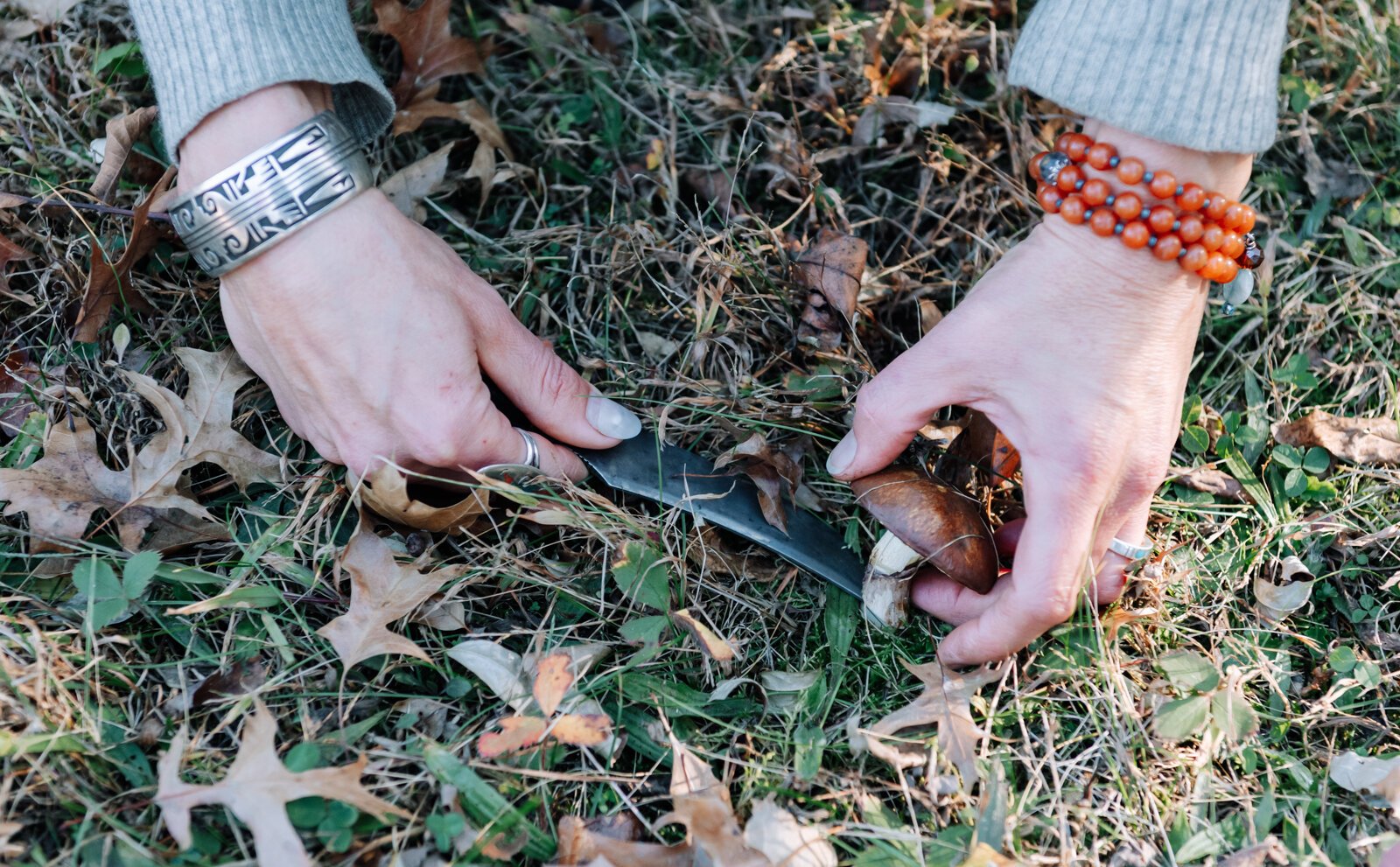 Claudia Hedeen of the Miami Tribe of Oklahoma, forages a mushroom from the genus Suillus with her dog Hobbes on Miami tribal property in Fort Wayne.