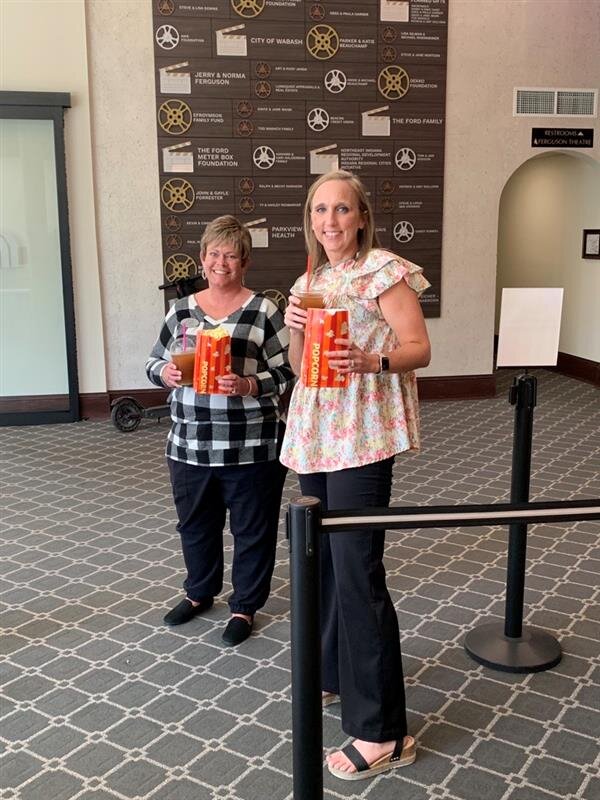 Kristi Unger, Director of Education, and Jamie Haupert, Education Specialist, celebrate Honeywell Values Week with popcorn and slushies at Eagles Theatre.
