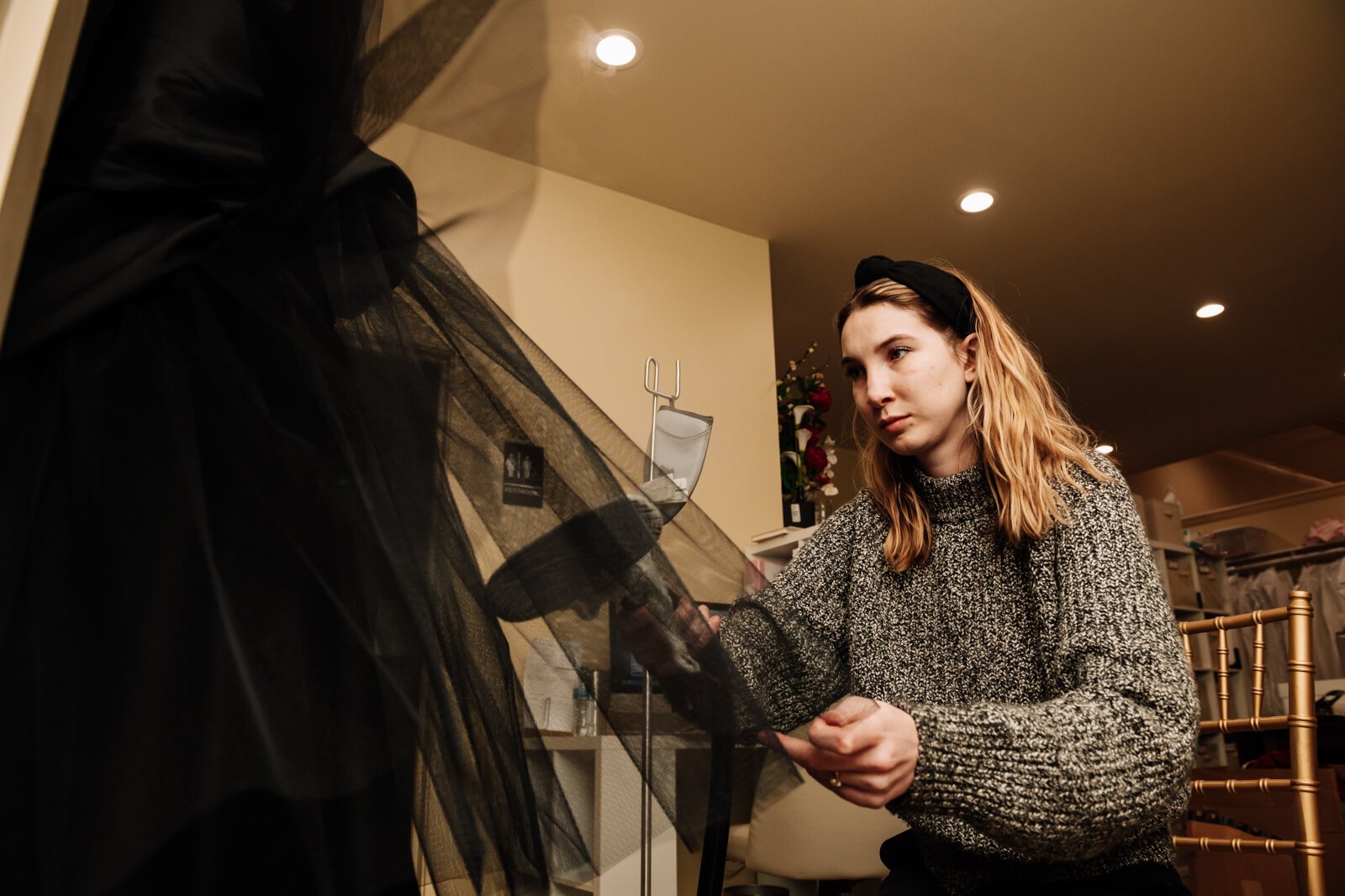 Bridal Stylist Morgan L. Miller works on steaming a black wedding dress at  Ellen's Bridal & Dress Boutique.