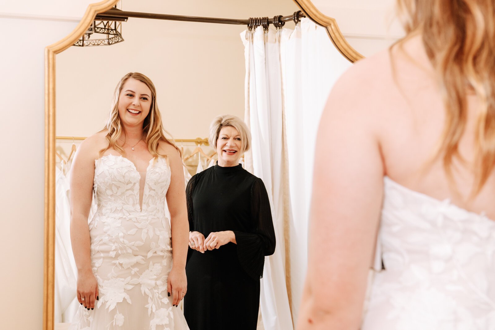Lisa Downs, owner of Ellen's Bridal & Dress Boutique, helps customer Bailey Lundmark with a dress she is trying on 