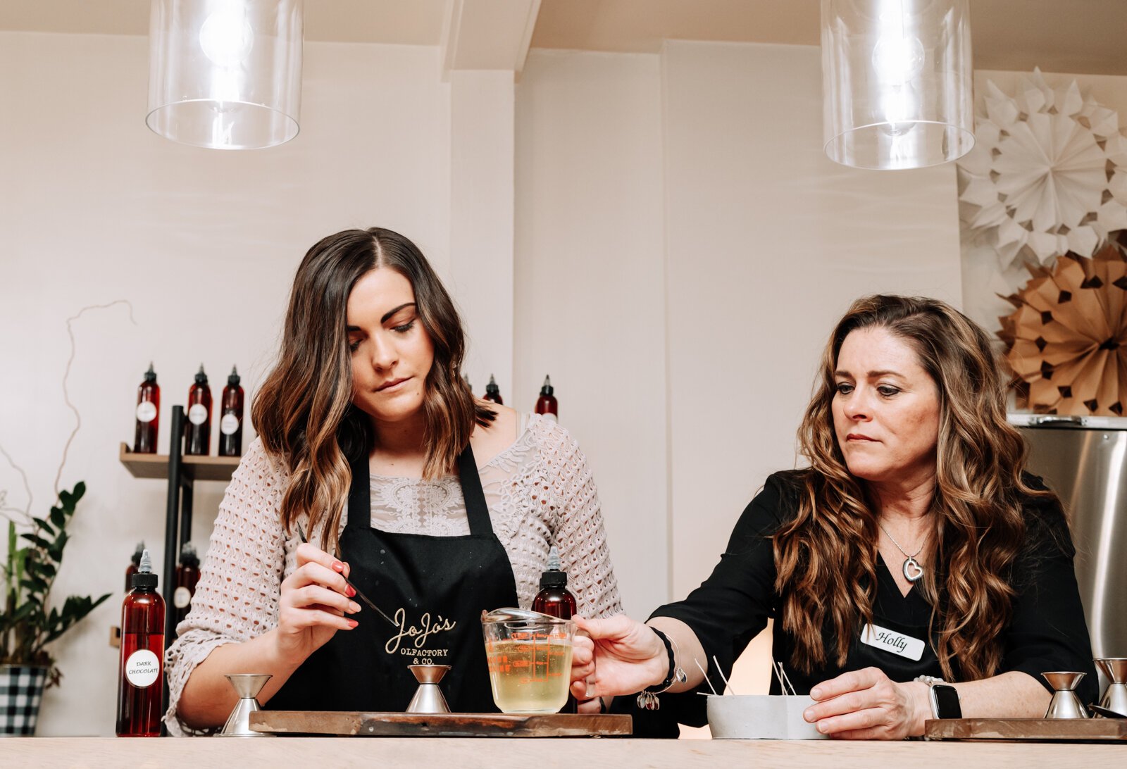 Abby Ward, left, and mother Holly Ward, owners, work together to make a Valentine's Day candle at JoJo's OlFactory Co.