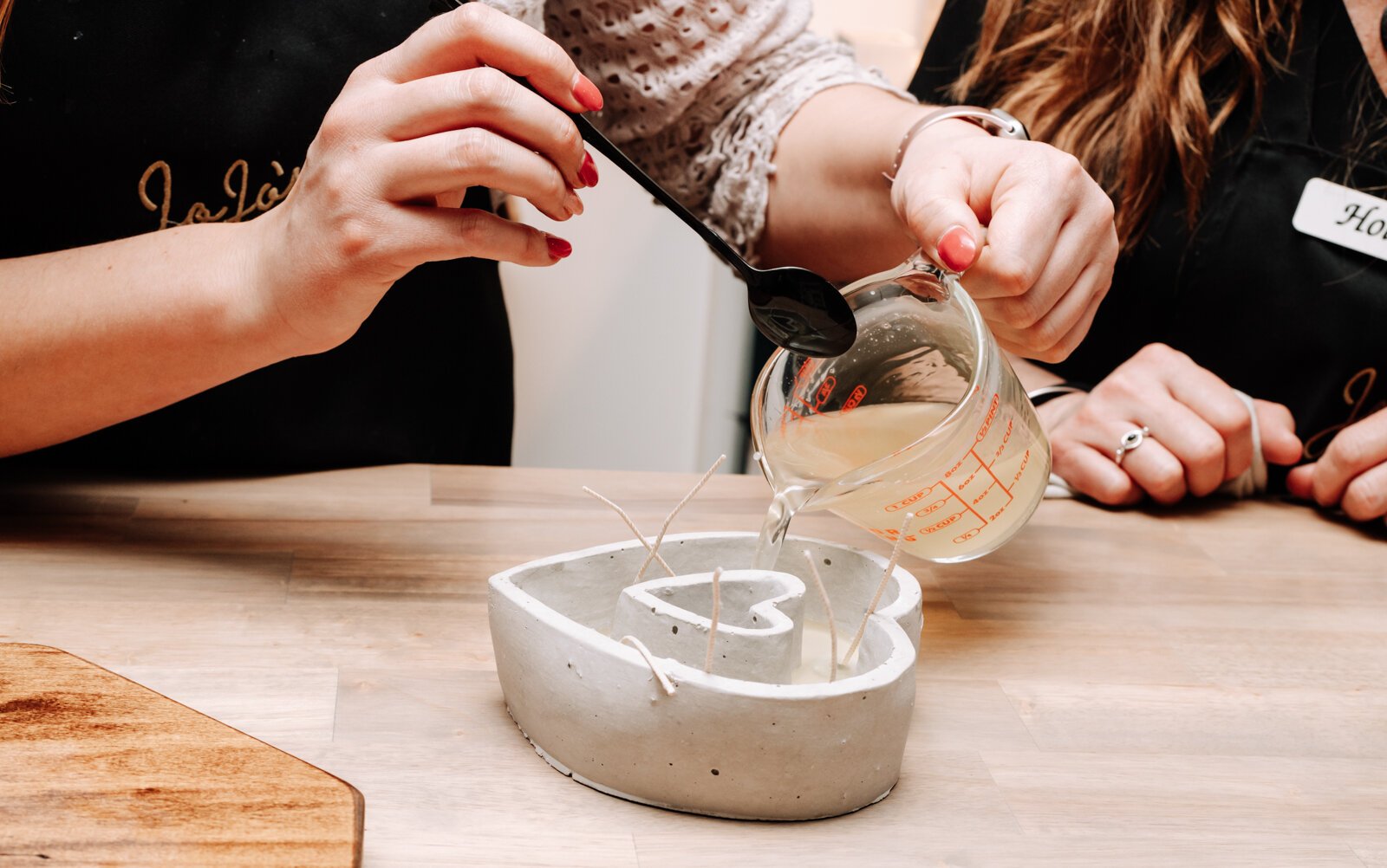 Abby Ward, left, and mother Holly Ward, owners, work together to make a Valentine's Day candle at JoJo's OlFactory Co.