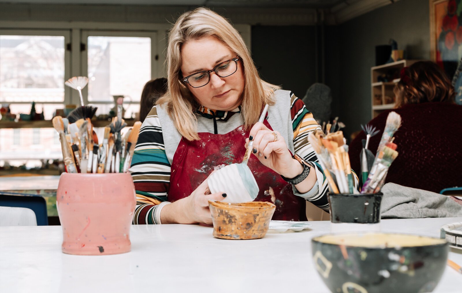 Lindsey Wilson works on her planter at Make It Your Own Art Studio.