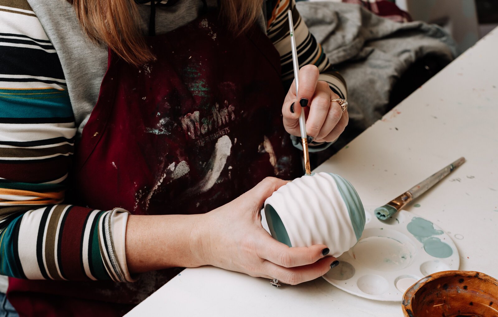 Lindsey Wilson works on her planter at Make It Your Own Art Studio.