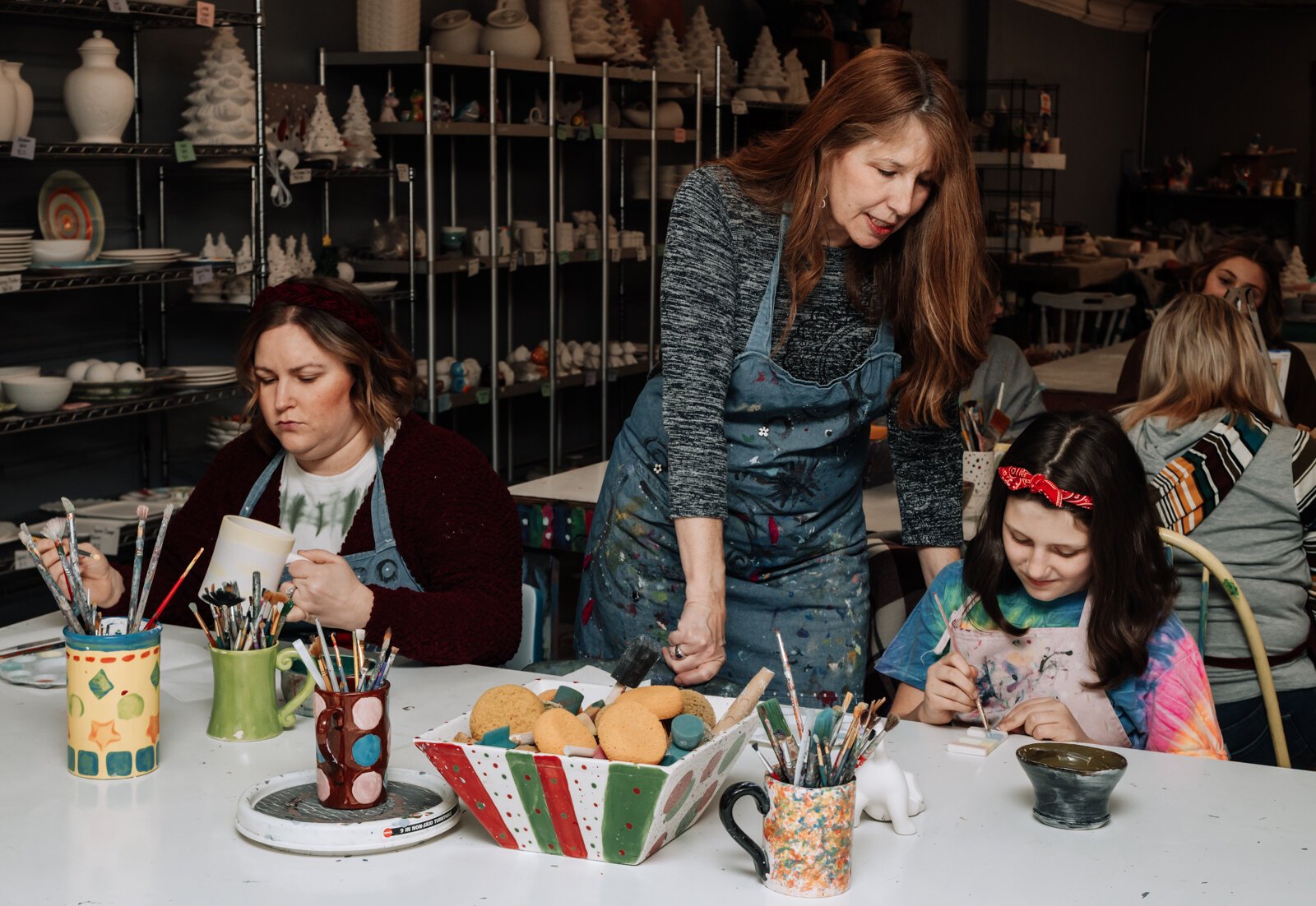 Karen Eilts-Walter, owner, helps customers Emerson Zwiebel, 11, right, and Andrea Zwiebel with their projects at Make It Your Own Art Studio.