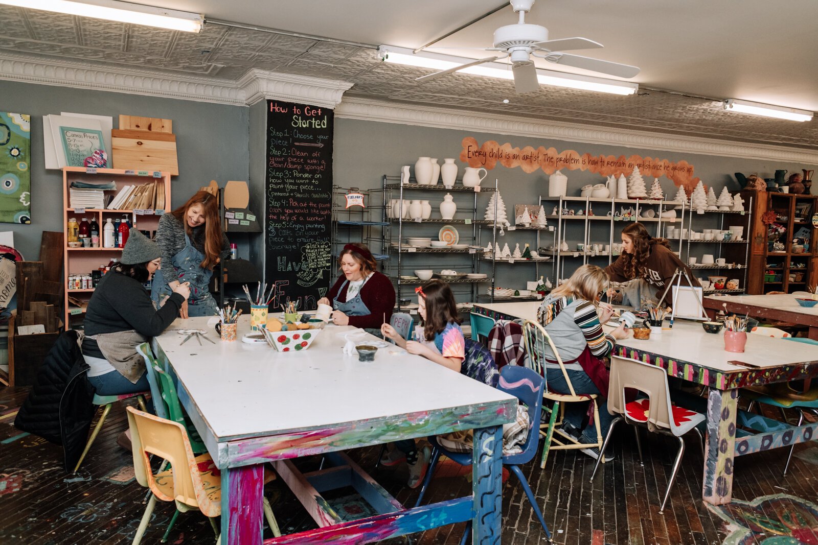 Customers work on painting their pottery pieces at Make It Your Own Art Studio.